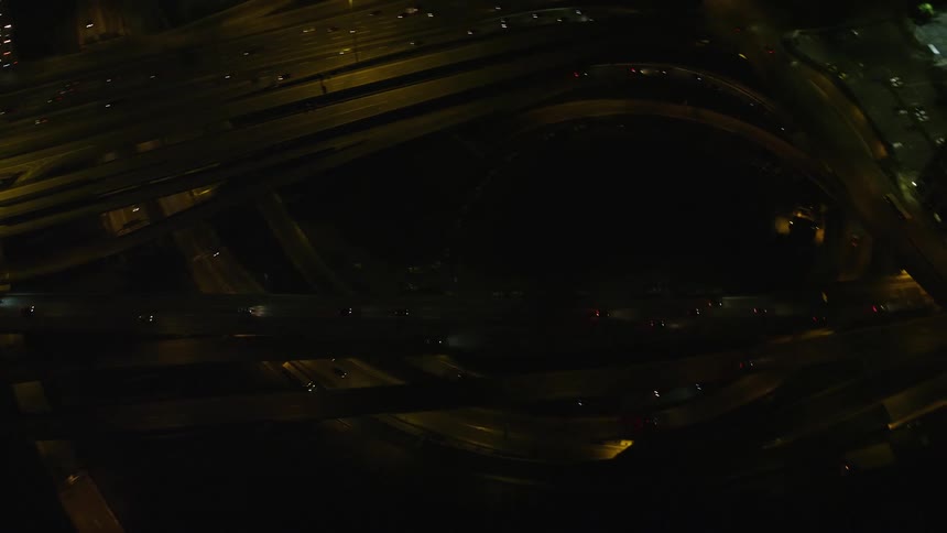 An aerial view of cars driving on highways at night