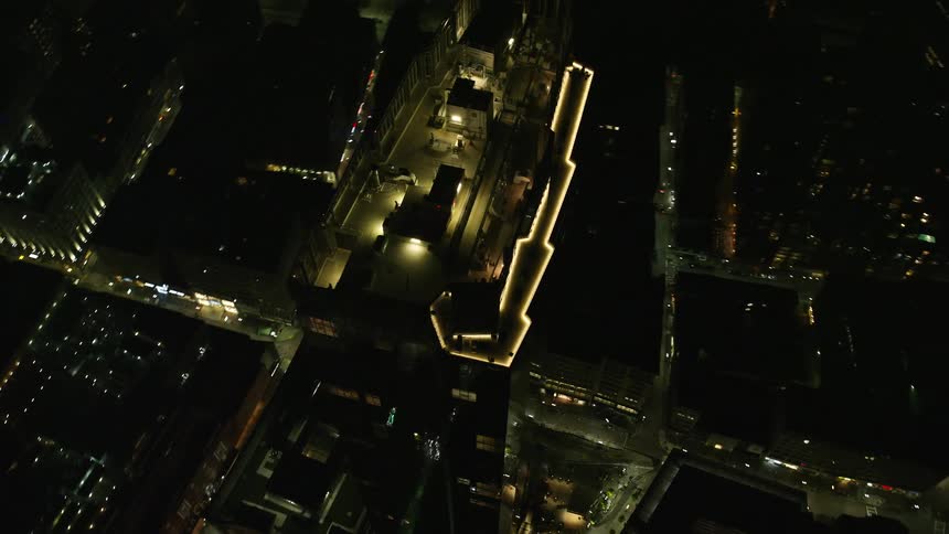 Aerial view of a metropolitan city at night with mirrored buildings