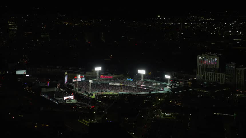 A baseball stadium in a city at night