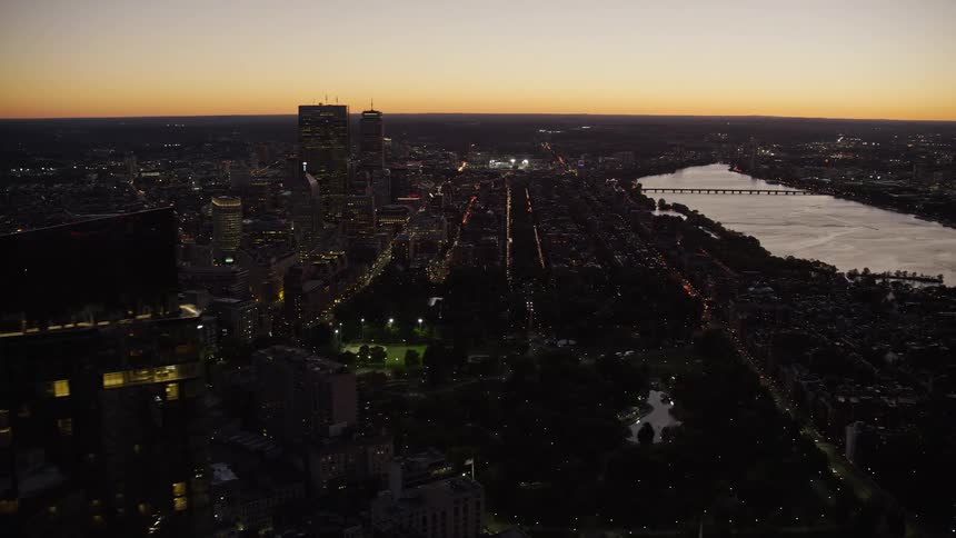 A large city with skyscrapers and a river at sunset