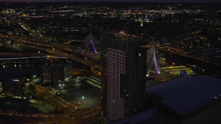 Several cars passing over a bridge at night in a big city
