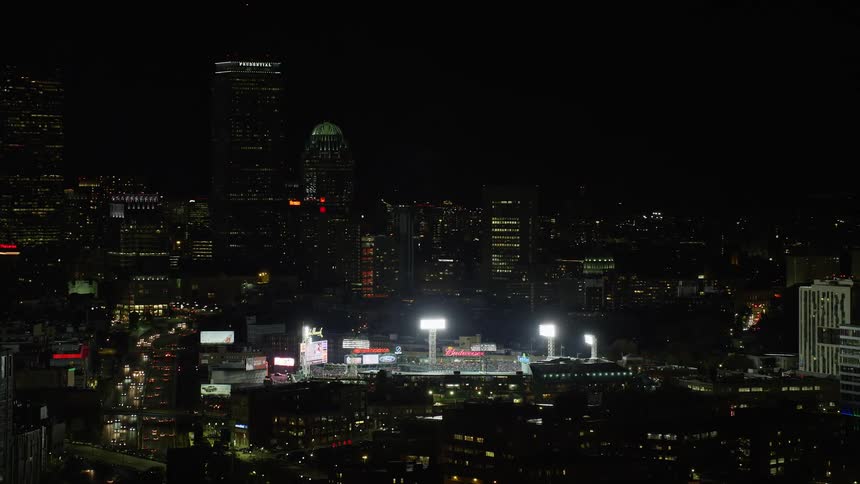 A stadium in a city with skyscrapers at night