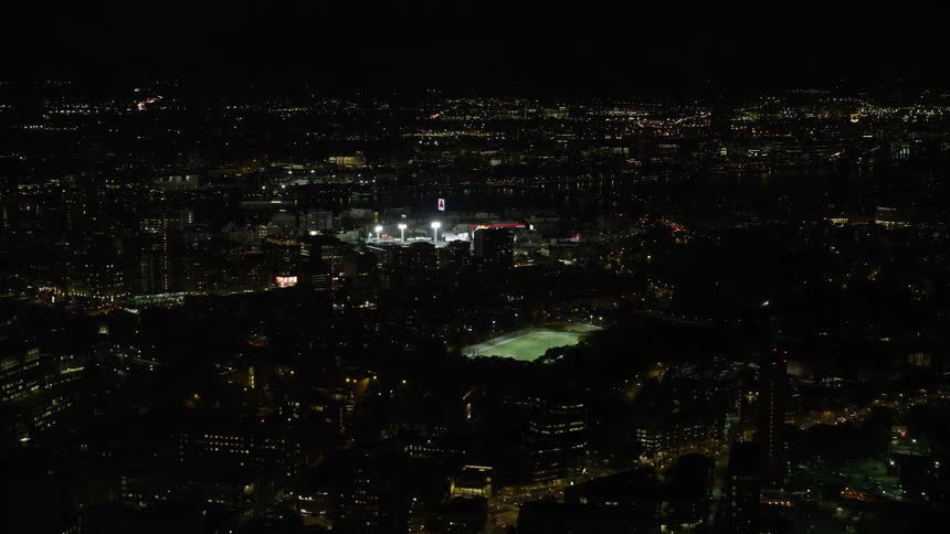 A stadium all lit up on a city night