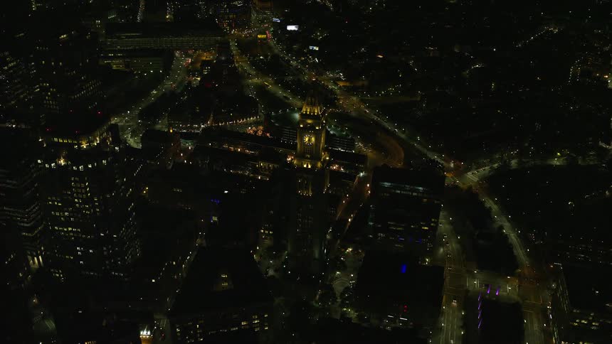 Aerial view of skyscrapers churches and a plaza in a downtown area of a city at night