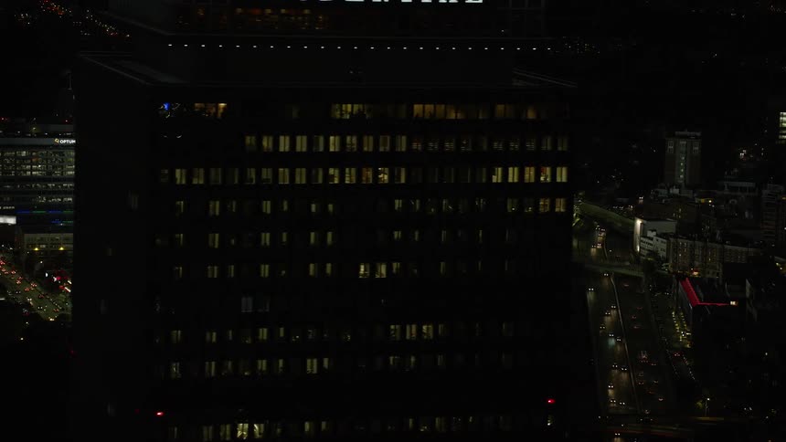 A stadium in the middle of a city and its all lit up by bright lights
