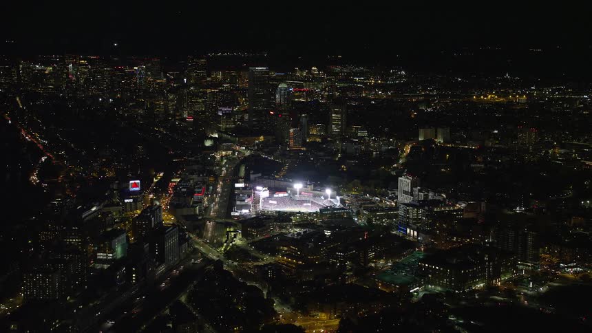 A city at night with a stadium with bright lights