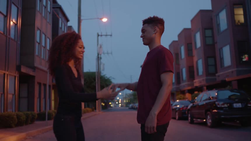 A man and woman are dancing in the street at dawn