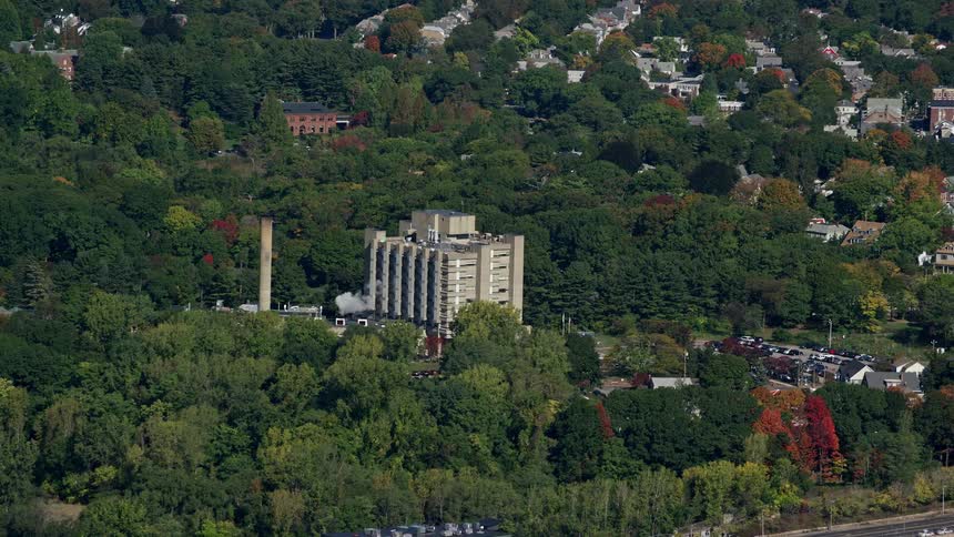 A large structure in the suburbs with a large array of trees