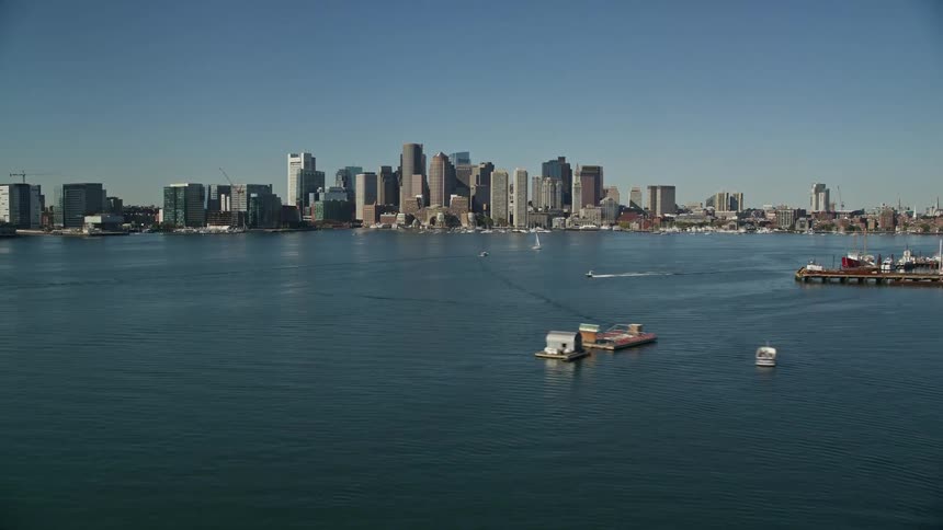 Boats on the water and skyscrapers in a metropolitan area at dawn
