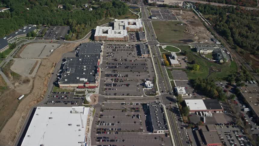 A structure with a huge parking lot and several cars parked