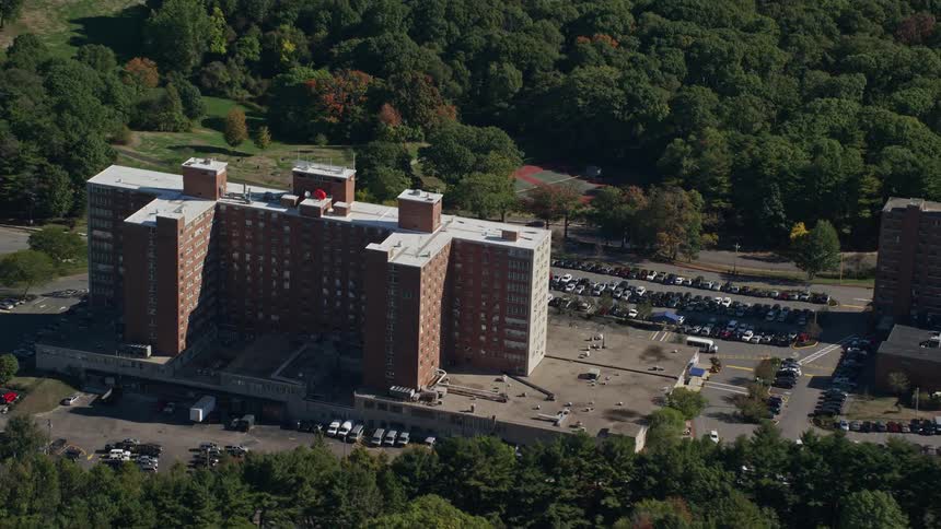 Aerial panorama of a building by the side of a highway with cars parked around it