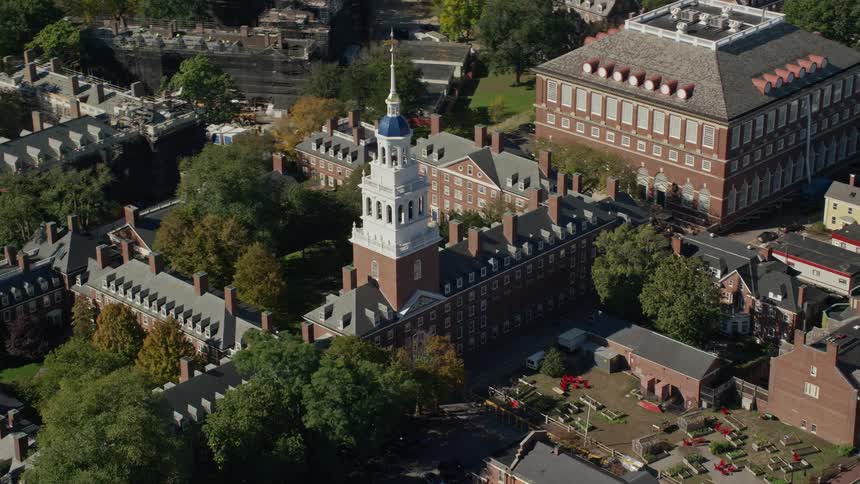 A building with a white tower on top and bare trees around it