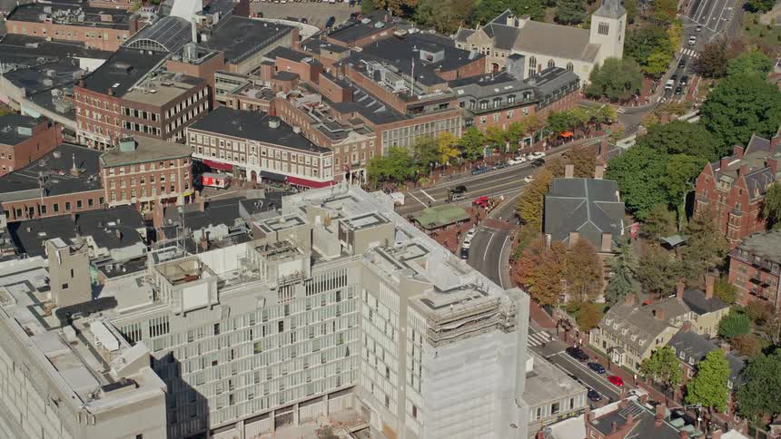 An aerial view of many neighborhood buildings along a busy city road