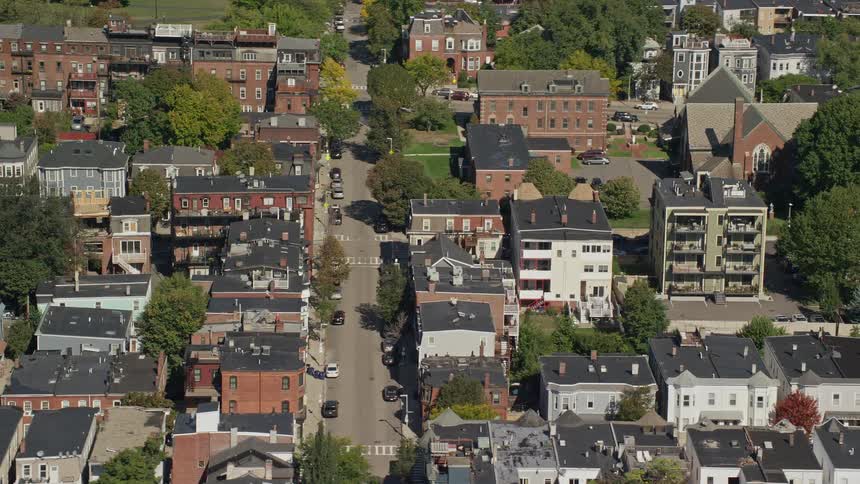 Vehicles park on the road throughout residential neighborhood