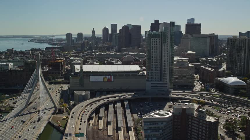 A big city with tall buildings and a bridge with a highway very busy with cars