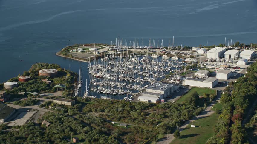 Several boats sit in the water at a pier on the coast