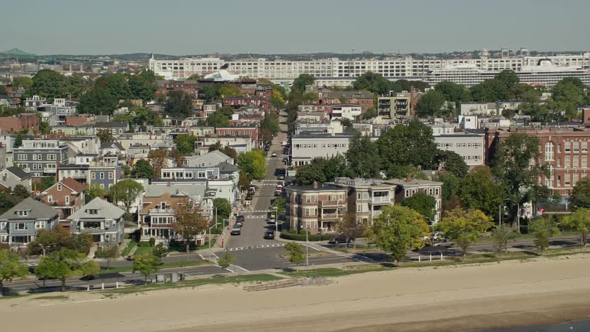 A residential area with low houses in front of the sand of a beach