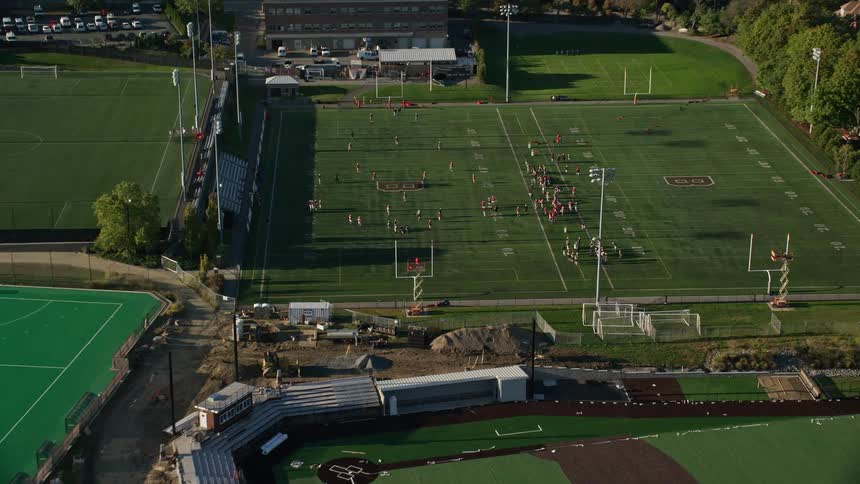 Aerial panorama of fields with people playing a game of american football