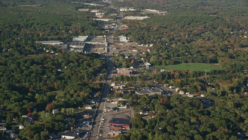 A rural area with many trees and a single highway in the middle