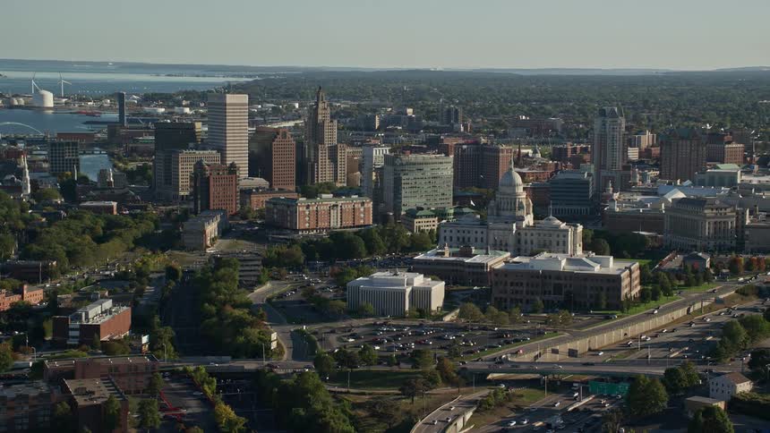 A daytime aerial shot of an urban area between the waterfront and a busy highway