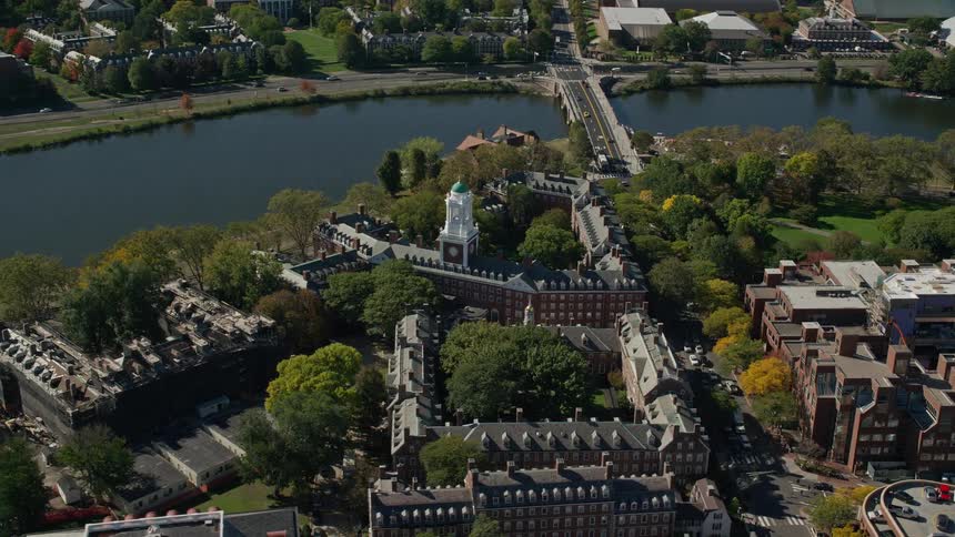 A building with a white tower on top next to a river with a bridge
