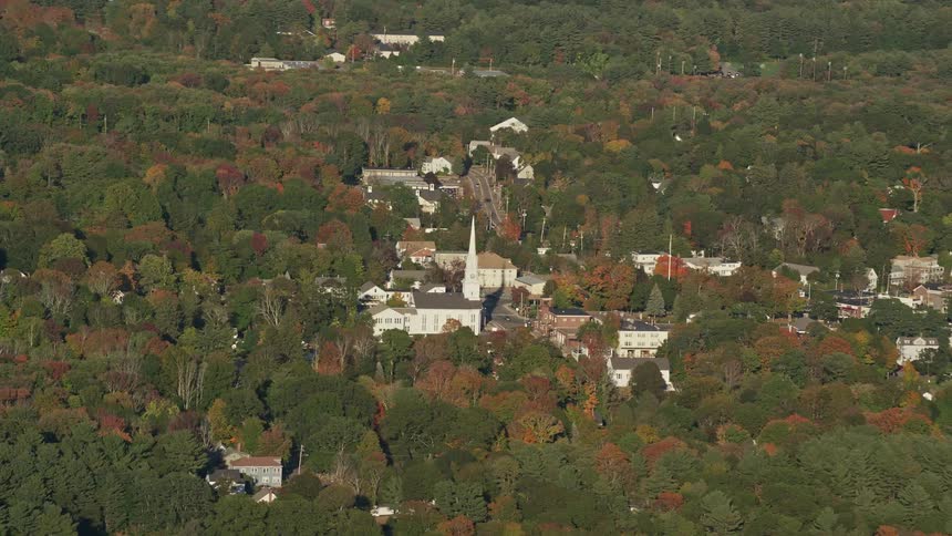 Aerial panorama of a city surrounded by nature with trees and a central church