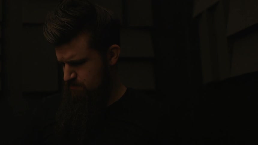 A man is playing drums in a dark area