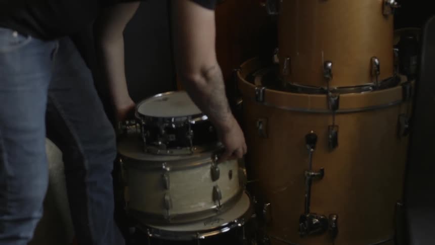 A man is stacking drums and moving them around