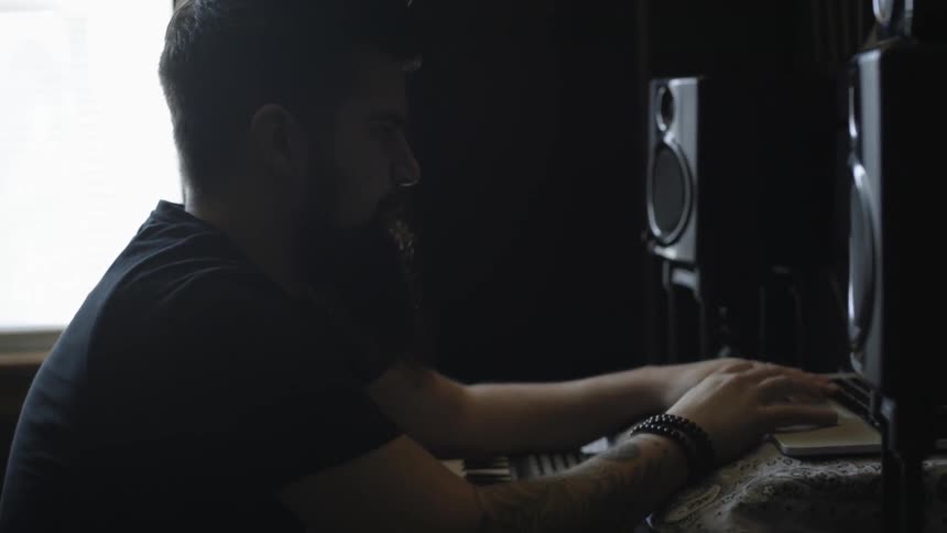 A man is typing on keyboard in a studio