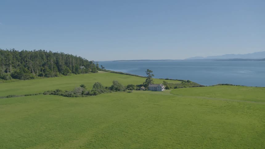 A beautiful mansion sits on a large estate with commanding views of the ocean and mountains