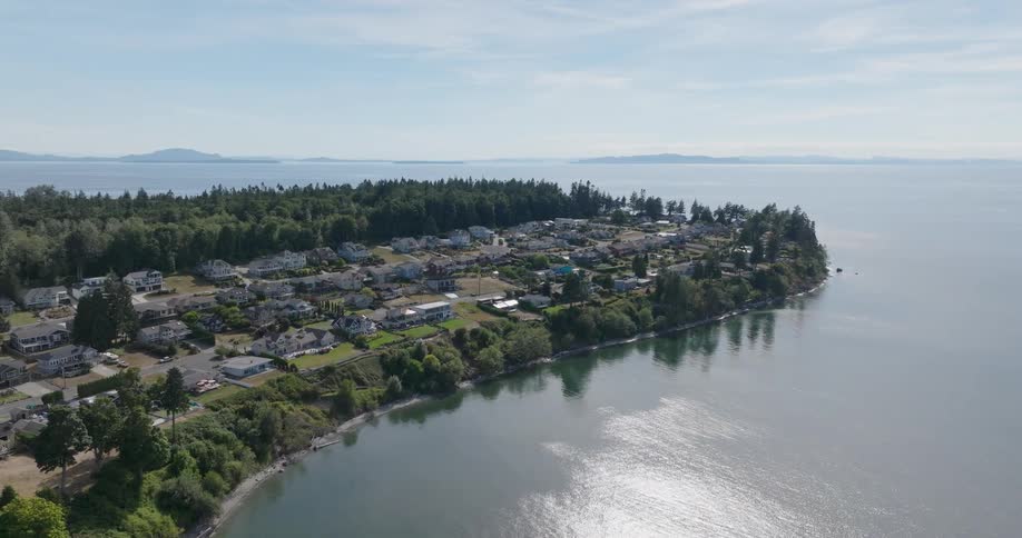 A residential neighborhood is nestled between woods and the seashore along a narrow peninsula