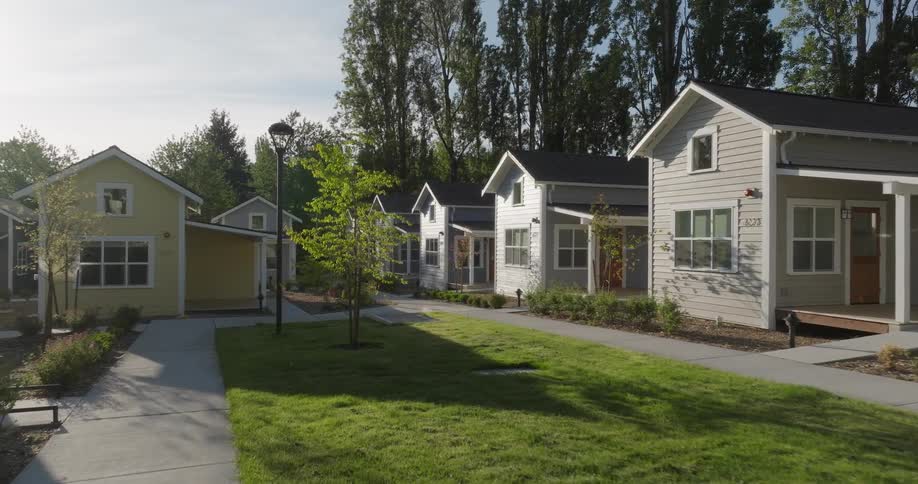 Sunshine filters between houses in a tiny home village community