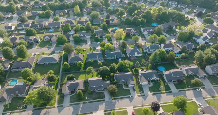 Overhead view of nice homes on large lots with manicured landscaping and swimming pools
