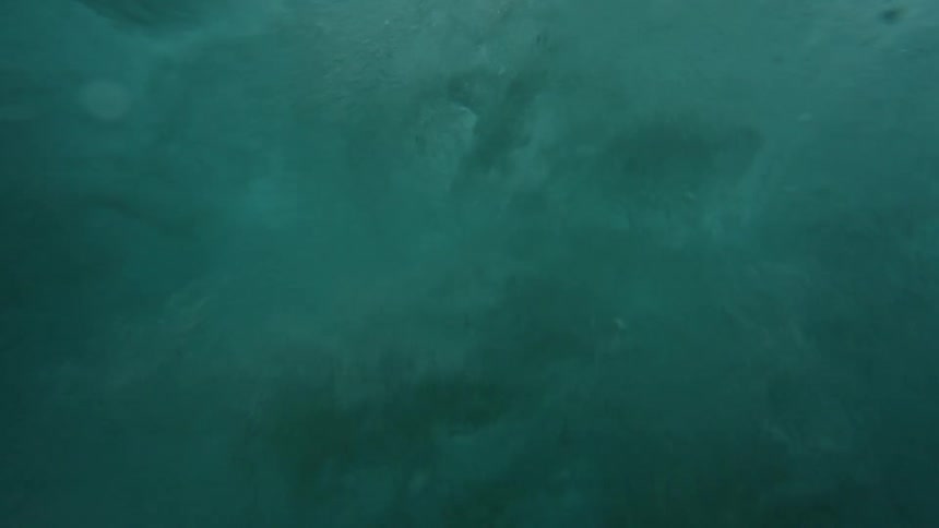 A view from inside the sea of a powerful breaking wave generating foam and bubbles