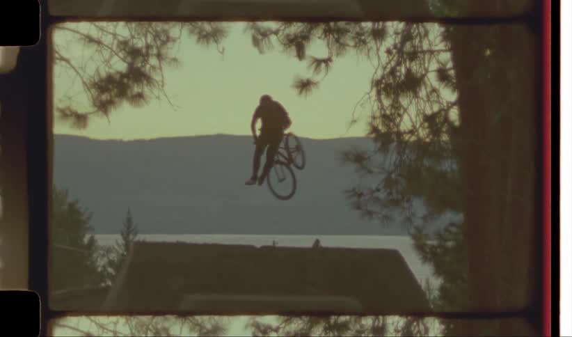Man performing bicycle stunt at sunset