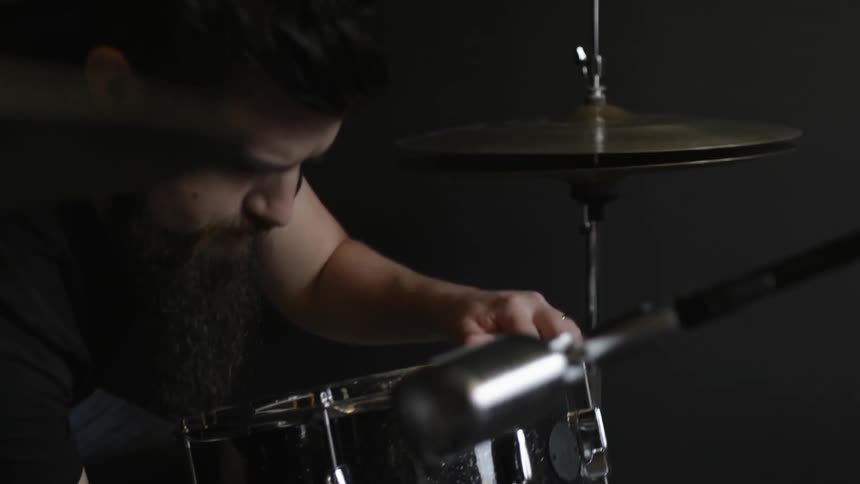 A man is placing drums down