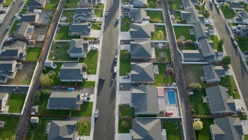 Traverse above parallel streets of suburban homes with manicured yards