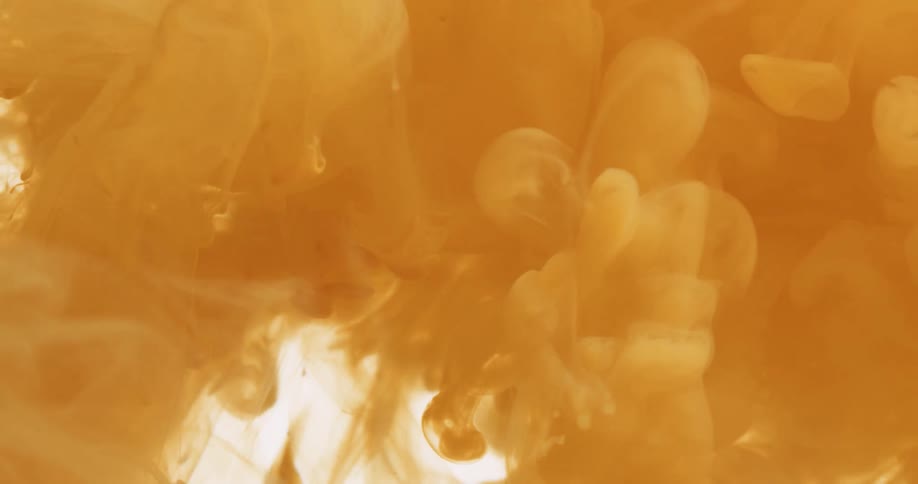Cloud of yellow ink expands on a white background