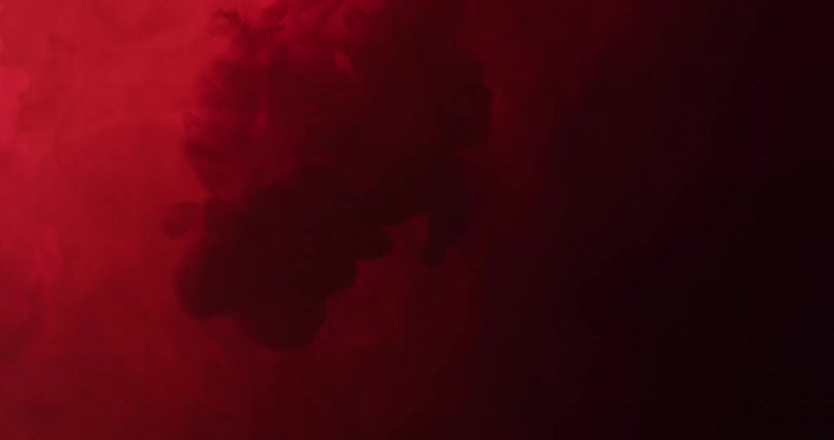 Abstract smokes being poured and expanding on a dark red background