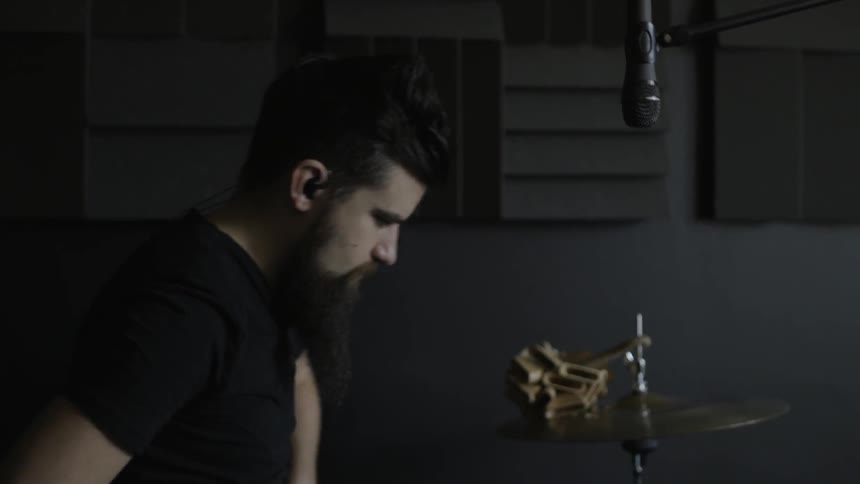 A man puts in ear plugs then starts drumming
