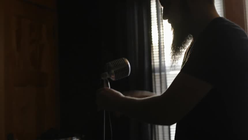 A man is setting up a microphone in a studio
