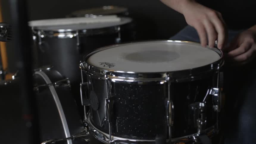 A man is putting together some drums