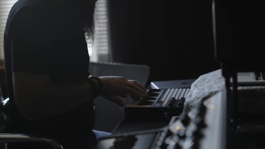 A person is sitting playing on a keyboard