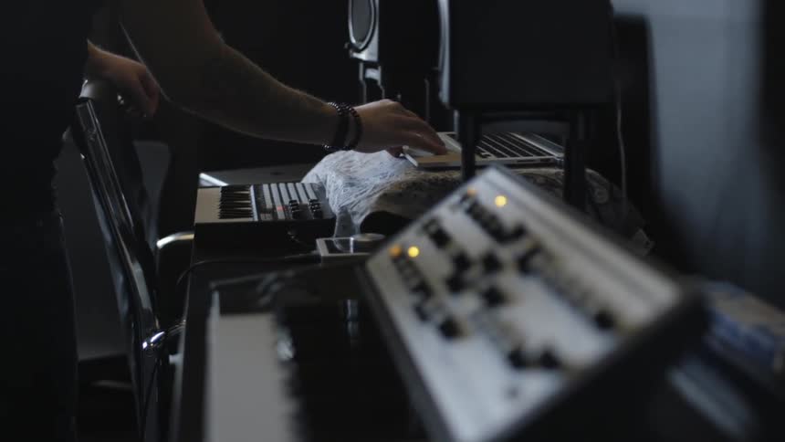 A man is turning a knob and using a laptop