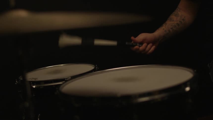 A person is using one stick to play drums