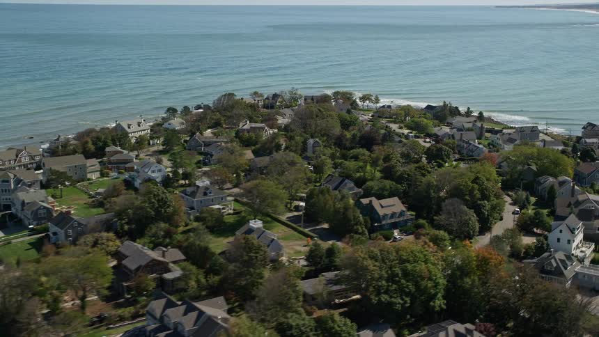 Streets run though the suburban neighborhood of a coastal community as waves splash against the shoreline