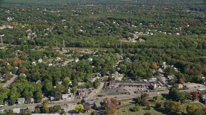 An aerial of a residential neighborhood surrounded by trees in autumn