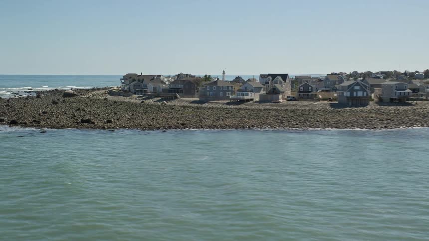 An aerial of a residential neighborhood along an ocean peninsula on a clear day