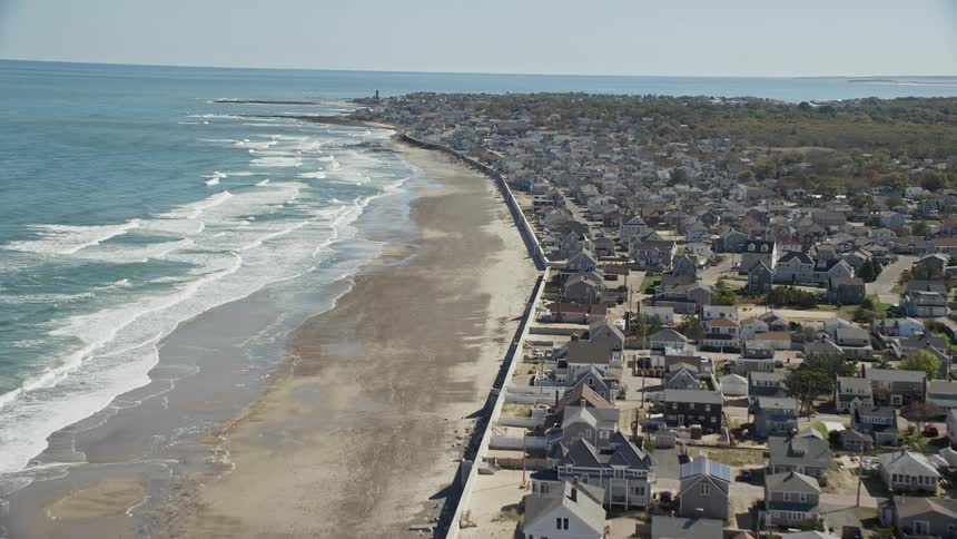 An aerial of a residential neighborhood along an ocean shore on a clear day