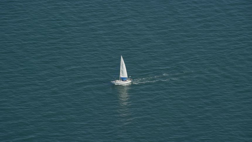 Aerial view of a small sailboat in the ocean